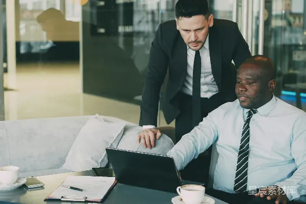 高清摄影 两位商人在办公室里一起使用笔记本电脑合作。