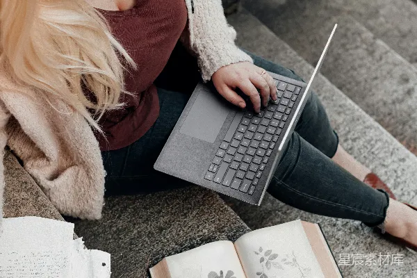 高清摄影 穿着白色针织毛衣的女性使用微软Surface Laptop。