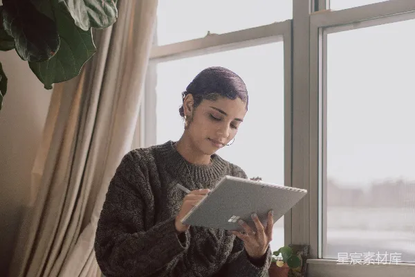 高清摄影 穿着黑色和灰色毛衣的人使用Surface设备。