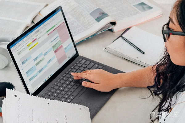 高清摄影 穿着白衬衫的女人在使用Microsoft Surface Laptop 3铂金版。
