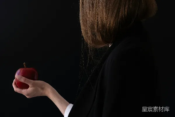 高清摄影 一个女人手里拿着一个苹果。