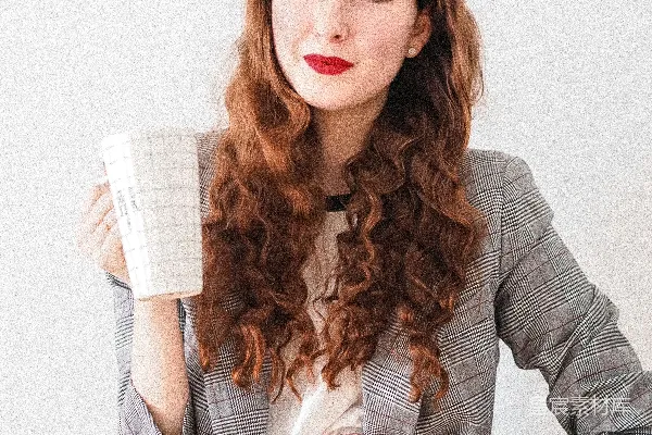 高清摄影 穿着灰色开衫的女人拿着一个白色的陶瓷杯子。
