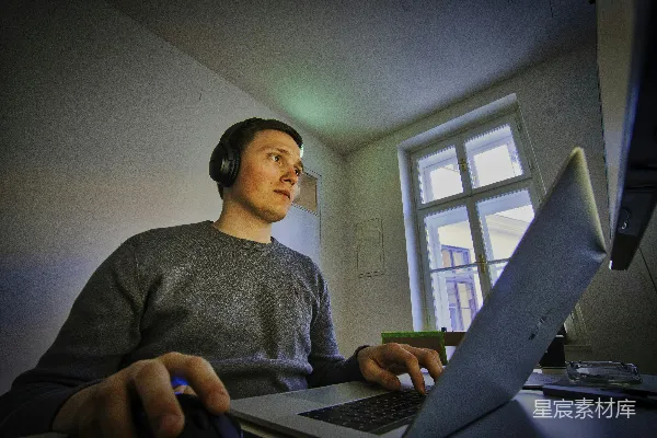 高清摄影 男人使用MacBook和无线耳机