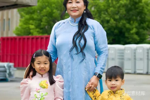 高清摄影 一个穿着传统越南服饰的女人和两个孩子在户外。