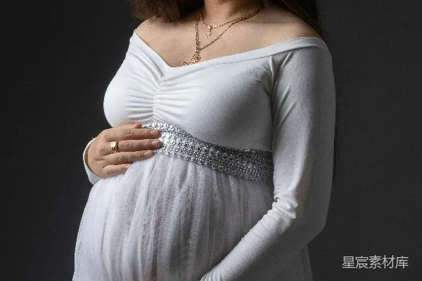 高清摄影 穿着白色连衣裙的孕妇面带幸福的笑容。