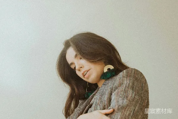 高清摄影 优雅女性肖像：温暖的格子外套与绿色流苏耳环