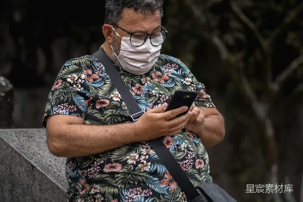 高清摄影 戴口罩的男士在户外使用手机
