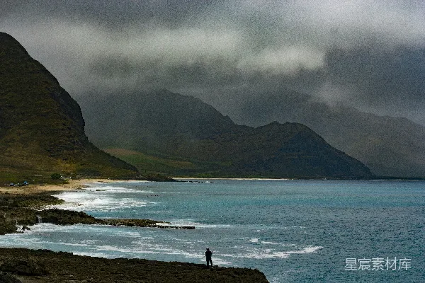 高清摄影 海边垂钓者与风雨交加的山景