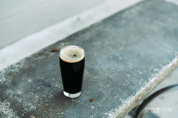 高清摄影 一杯深色啤酒在混凝土边沿