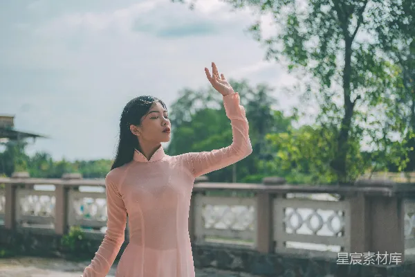 高清摄影 一个穿着粉红色连衣裙的女人举着手臂