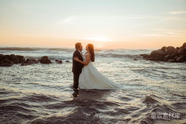 高清摄影 夕阳下海中的婚礼夫妇