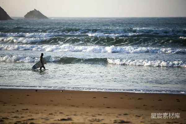 高清摄影 冲浪者在海岸边行走