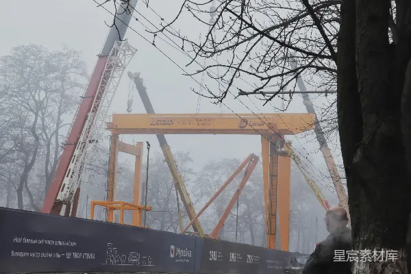 高清摄影 雾中工业场景：起重机与行人