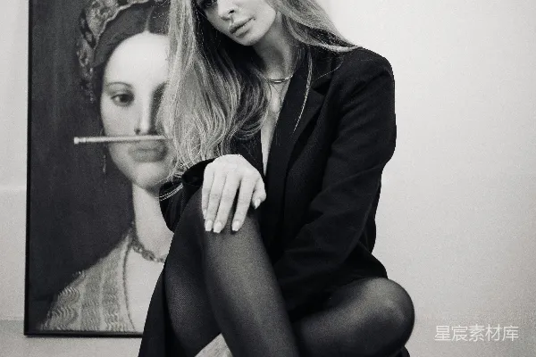 高清摄影 黑白艺术肖像：坐在画作前的优雅女性