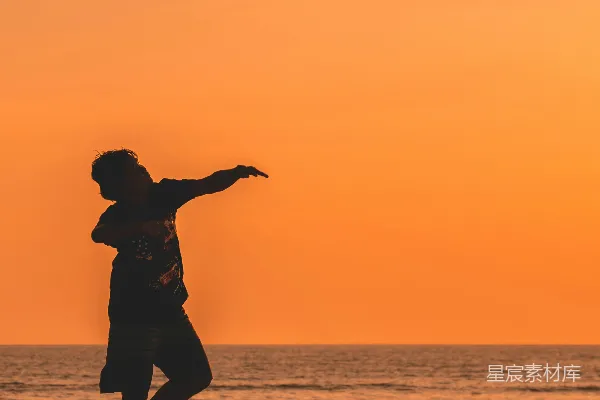高清摄影 夕阳下的海滩踢球