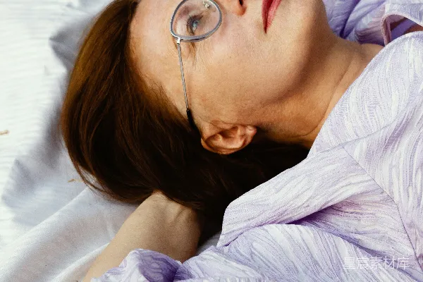高清摄影 悠闲时光：戴眼镜的女性躺在白色毯子上