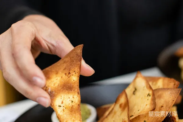 高清摄影 一个人在吃装有酱料的Nachos