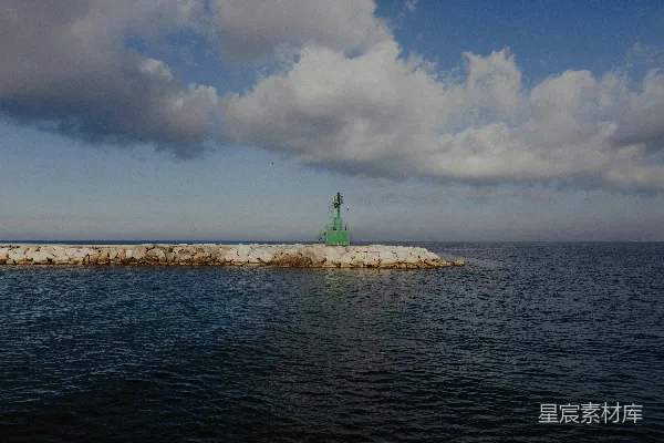高清摄影 海洋中一块岩石突起处的一座绿灯塔