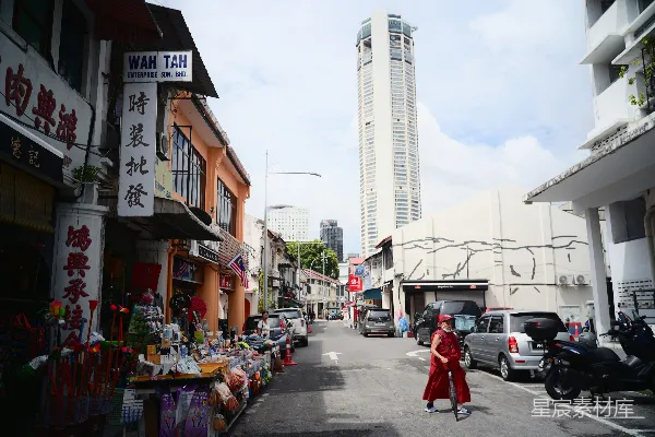 高清摄影 一个人走在有商店和高楼的街道上。