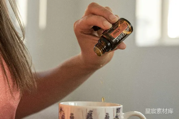 高清摄影 一个女人坐在桌子旁给杯子倒茶。