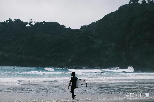 高清摄影 冲浪者在海滩上行走