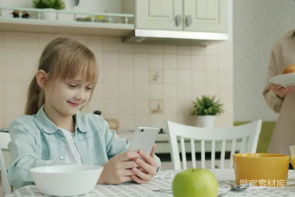 高清摄影 家庭早餐时光：孩子专注玩手机