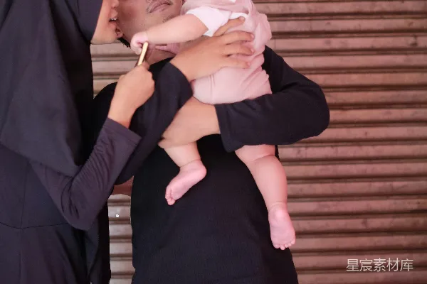高清摄影 家庭温馨时刻：父亲怀抱婴儿，母亲亲吻儿子