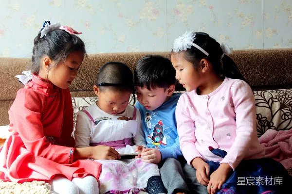 高清摄影 四兄妹专注玩手机的温馨时刻
