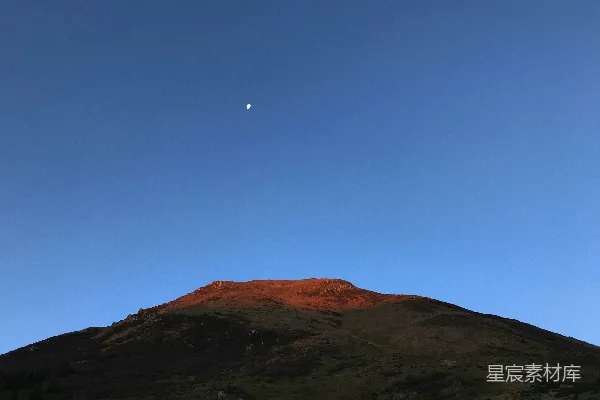 高清摄影 夕阳下的山峰与新月