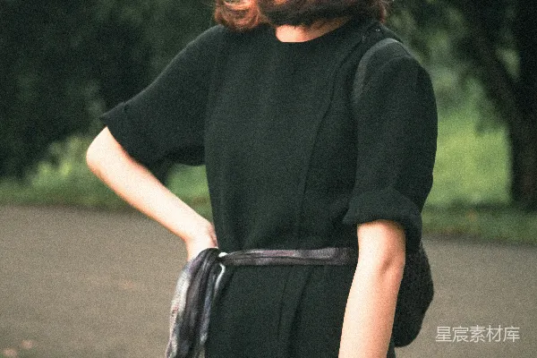 高清摄影 黑衣女子在绿树环绕的公园中漫步