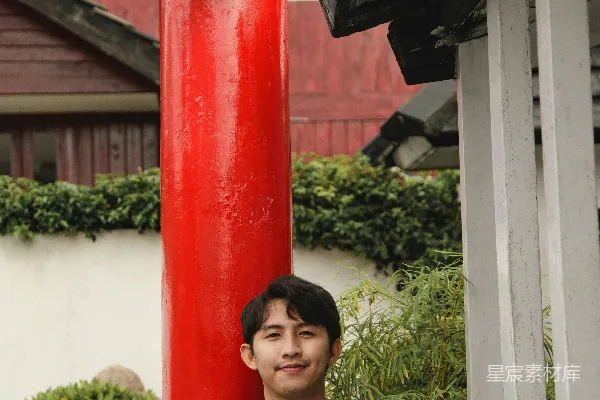 高清摄影 身穿传统服饰的男子在红色柱子前微笑