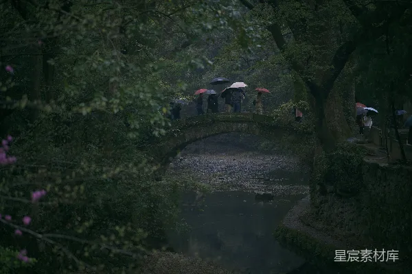 高清摄影 一群人在桥上站着，撑着伞。
