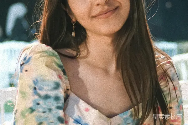 高清摄影 一个女人坐在一张白色的椅子旁边，旁边是一张桌子。