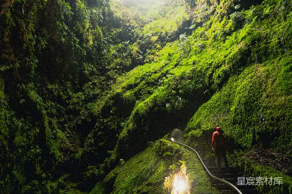 高清摄影 白天人们走在绿山之间的步行道上
