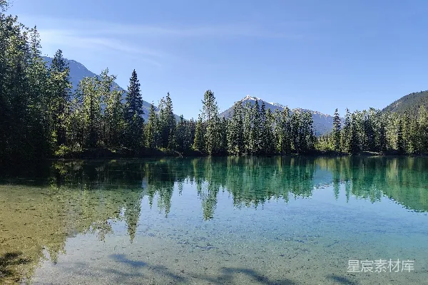 高清摄影 湖畔有树木和山峰的背景。
