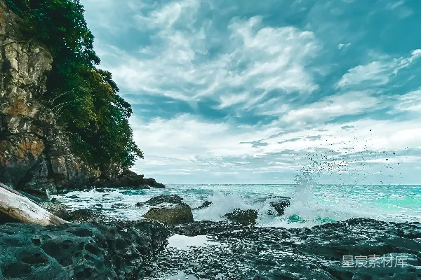 高清摄影 白天海浪拍击岩石，白云蓝天背景下