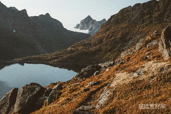 高清摄影 棕色的岩石山位于一个湖泊附近，在白天。