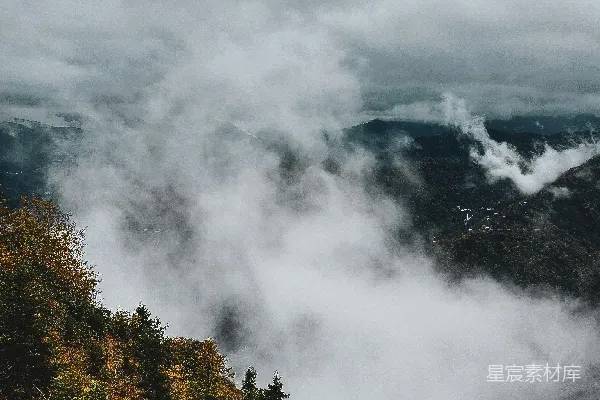 高清摄影 山中绿树映衬着白云，白天景色如画。