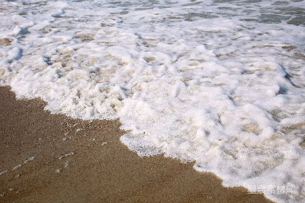 高清摄影 一片沙滩上，波浪时进时出地涌动着。