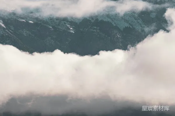 高清摄影 云雾笼罩的山峦，前景有一叶小舟。