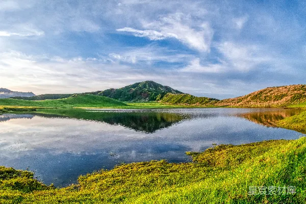 高清摄影 蓝天之下湖边绿草丛中的田野在白天
