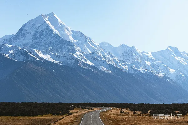 高清摄影 路旁有座被雪覆盖的山峦