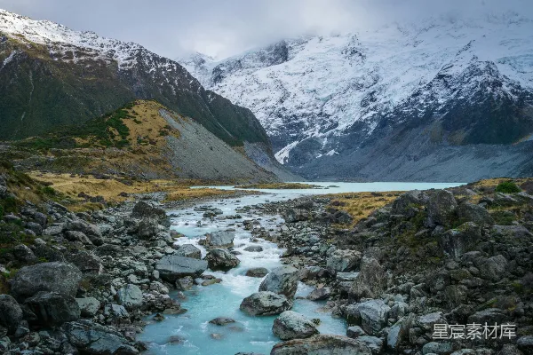 高清摄影 近山覆盖白雪的河流旁边有灰色岩石的大河