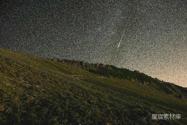 高清摄影 一架飞机在一片草坡上空飞过，夜空中星光闪烁。