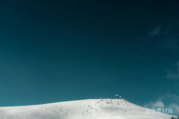 高清摄影 覆盖着白雪的山坡背景是蓝天。