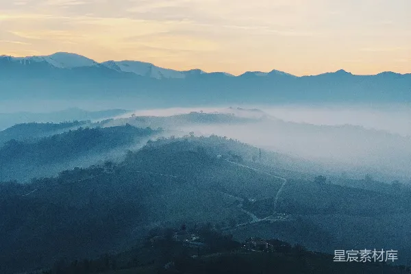 高清摄影 远处山谷一片雾气缭绕，山峦在背景中隐约可见。